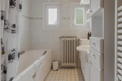 a white bathroom with a tub and a sink at Le Montagny Sejour Cosy au Coeur des Alpes in Sallanches