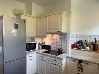 a kitchen with white cabinets and a refrigerator at Le Montagny Sejour Cosy au Coeur des Alpes in Sallanches