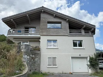 a white house with a balcony on top of it at Le Montagny Sejour Cosy au Coeur des Alpes in Sallanches