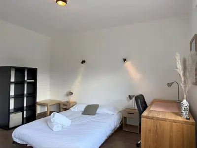 a bedroom with two beds and a desk with a desk at Le Montagny Sejour Cosy au Coeur des Alpes in Sallanches
