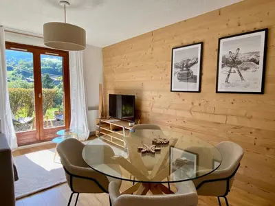a dining room with a glass table and chairs at Le Sapin A5 in Megève