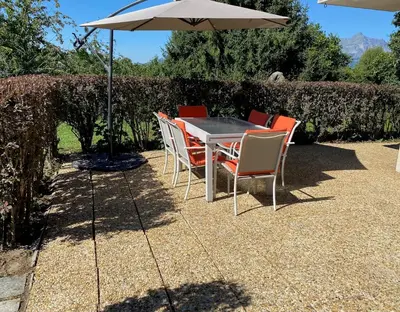 a table with chairs and an umbrella on a patio at Le Sapin A5 in Megève