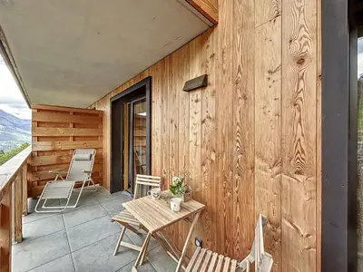 a patio with a table and chairs on a wooden wall at Charmant appartement à Combloux près des pistes avec parking - FR-1-560-166 in Combloux