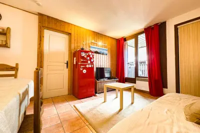 a room with two beds and a red refrigerator at Stay in the heart of Chamonix close to the slopes in Chamonix-Mont-Blanc