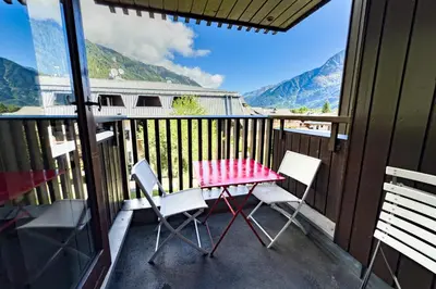 a table and chairs on a balcony with mountains at Stay in the heart of Chamonix close to the slopes in Chamonix-Mont-Blanc