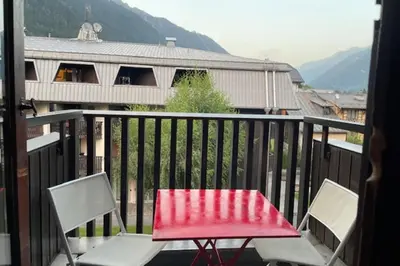 a red table and two chairs on a balcony at Stay in the heart of Chamonix close to the slopes in Chamonix-Mont-Blanc