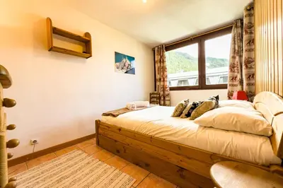 a bedroom with a bed with a large window at Stay in the heart of Chamonix close to the slopes in Chamonix-Mont-Blanc