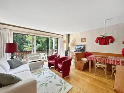 a living room with a couch and a dining room at MUD212 2 pieces 4 pers proche centre les Carroz in Les Carroz d'Araches