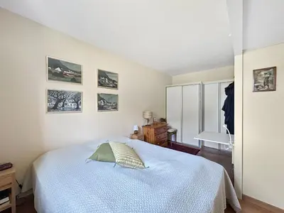 a bedroom with a bed and pictures on the wall at MUD212 2 pieces 4 pers proche centre les Carroz in Les Carroz d'Araches