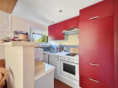 a kitchen with red cabinets and white counters at MUD212 2 pieces 4 pers proche centre les Carroz in Les Carroz d'Araches
