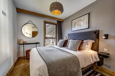 a bedroom with a large bed and a mirror at Residence Blanc Mont Blanc in Chamonix-Mont-Blanc