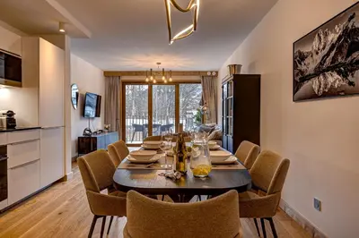 a dining room with a table and some chairs at Residence Blanc Mont Blanc in Chamonix-Mont-Blanc
