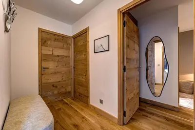 a bedroom with a wooden door and a mirror at Residence Blanc Mont Blanc in Chamonix-Mont-Blanc