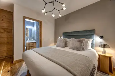 a bedroom with a large bed and a chandelier at Residence Blanc Mont Blanc in Chamonix-Mont-Blanc