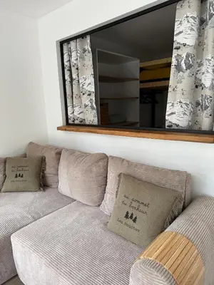 a large mirror above a couch in a room at Appartement 1 chambre, balcon, vue montagne, aux pieds des pistes in Les Houches
