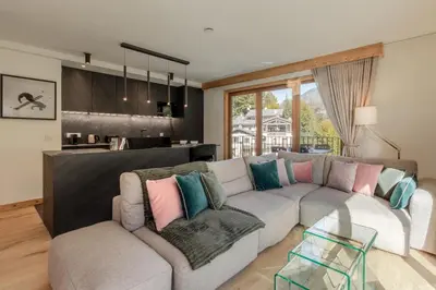 a living room with a gray couch with colorful pillows at Blanc Mont Blanc in Chamonix-Mont-Blanc