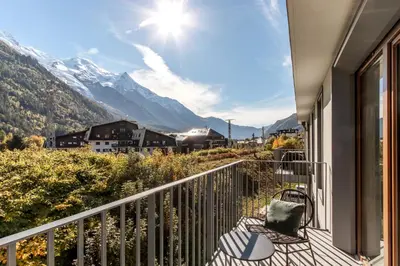 a balcony with a chair and a view of mountains at Blanc Mont Blanc in Chamonix-Mont-Blanc