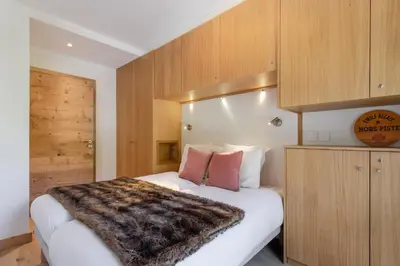 a bedroom with a white bed with a fur blanket on it at Blanc Mont Blanc in Chamonix-Mont-Blanc