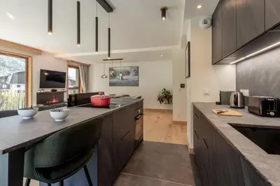 a kitchen with a large counter top and a living room at Blanc Mont Blanc in Chamonix-Mont-Blanc