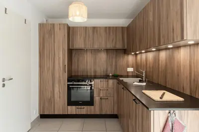 a kitchen with wooden cabinets and a sink at Le Méribel - Terrasse 83m2 - Vue Mont-Blanc in Sallanches