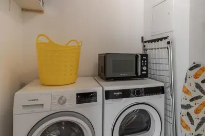 a laundry room with a microwave and a washing machine at Le Méribel - Terrasse 83m2 - Vue Mont-Blanc in Sallanches