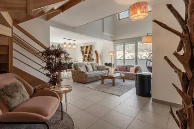 a living room with couches and a staircase at Le Méribel - Terrasse 83m2 - Vue Mont-Blanc in Sallanches