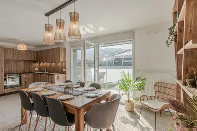 a kitchen and dining room with a wooden table and chairs at Le Méribel - Terrasse 83m2 - Vue Mont-Blanc in Sallanches