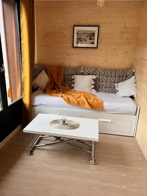 a room with a bed with a table in it at Joli studio hypercentre in Les Carroz d'Araches
