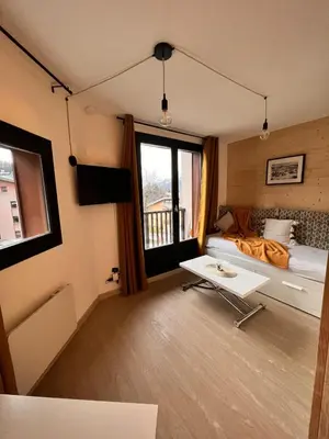 a room with a bed and a table in it at Joli studio hypercentre in Les Carroz d'Araches