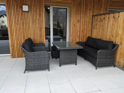 a patio with two chairs and a table and a couch at Le Doran - Terrasse & Vue Mont Blanc in Sallanches