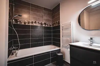 a bathroom with a bath tub and a sink at Le Doran - Terrasse & Vue Mont Blanc in Sallanches