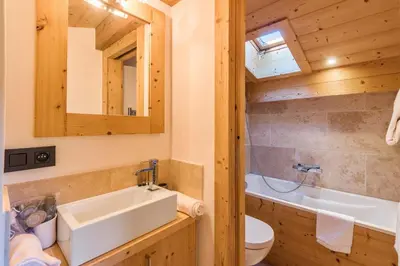 a bathroom with a sink and a toilet and a mirror at Appartement Bridan - Welkeys in Megève