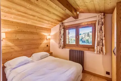 a bedroom with a bed and a window at Appartement Bridan - Welkeys in Megève