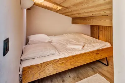 a bed in a room with a wooden ceiling at Appartement Bridan - Welkeys in Megève