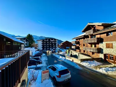 a car parked on a street with snow covered buildings at Edelweiss Résidence plein centre de la station rez de chaussée 50 m des navettes gratuites belle terrasse et grand parking privé en sous sol in Les Carroz d'Araches