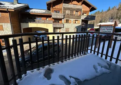 a fence with footprints in the snow in front of a house at Edelweiss Résidence plein centre de la station rez de chaussée 50 m des navettes gratuites belle terrasse et grand parking privé en sous sol in Les Carroz d'Araches