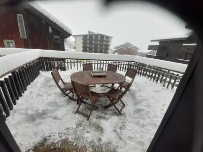 a table and chairs in the snow on a balcony at Edelweiss Résidence plein centre de la station rez de chaussée 50 m des navettes gratuites belle terrasse et grand parking privé en sous sol in Les Carroz d'Araches