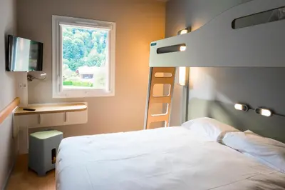 a bedroom with a bunk bed and a window at Ibis Budget Sallanches in Sallanches