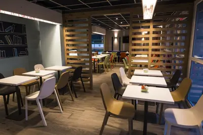 a restaurant with tables and chairs in a room at Ibis Budget Sallanches in Sallanches