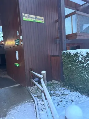 a building with a sign on the side of it in the snow at Au nid du Lay in Les Contamines-Montjoie