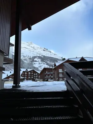 a building with snow on the ground and a mountain at Au nid du Lay in Les Contamines-Montjoie