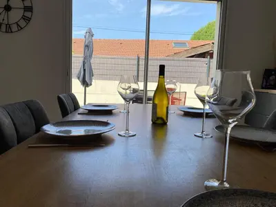 a table with a bottle of wine and glasses on it at Le Mariloz - Vacances famille ski & montagne in Passy
