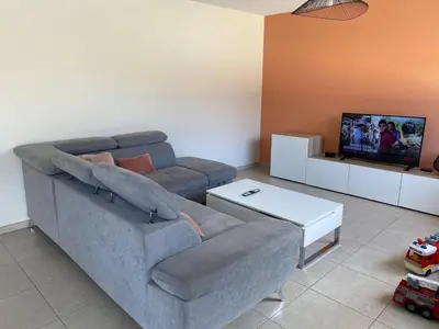 a living room with a couch and a tv at Le Mariloz - Vacances famille ski & montagne in Passy