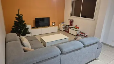 a living room with a couch and a christmas tree at Le Mariloz - Vacances famille ski & montagne in Passy