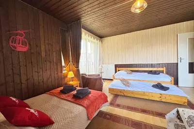 a bedroom with two beds and a chair at Charming studio near the slopes and the city in Megève