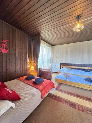 a bedroom with two beds and a couch in it at Charming studio near the slopes and the city in Megève