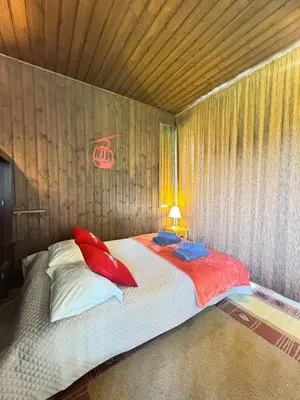 a bedroom with a bed with red pillows on it at Charming studio near the slopes and the city in Megève