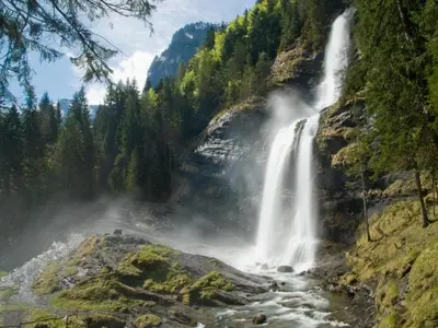 a waterfall in the middle of a forest at Charming Mountain Getaway in Samoëns