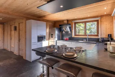 a kitchen with a large island in a wooden kitchen at Chalet Mont Blanc in Cordon