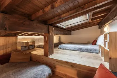 two beds in a room with wooden floors at Les Chaumes - T3 moderne piscine in Sallanches